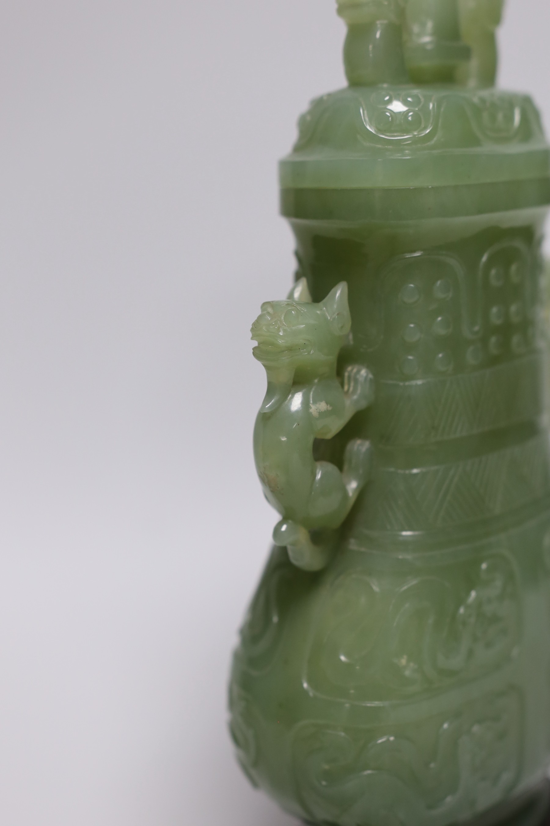A Chinese carved bowenite jade vase and cover on hardwood stand, 23cm, with fitted case